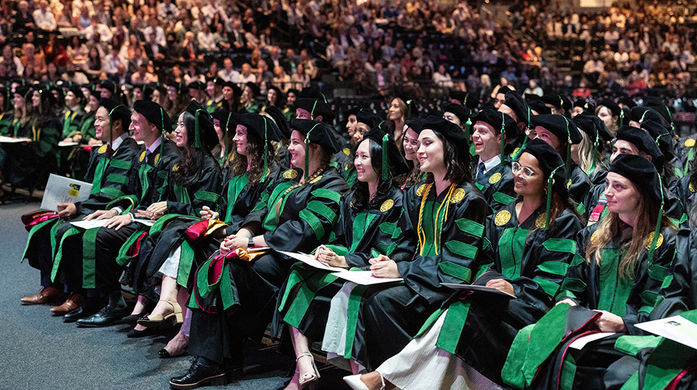 Members of the Stritch Class of 2026 wearing their cap and gowns and smiling during their Commencement Ceremony